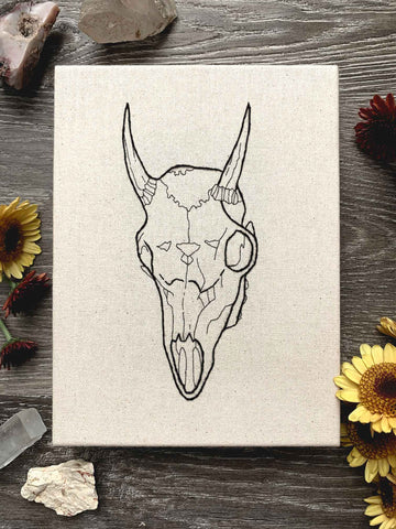 sewn embroidery of an animal goat skull