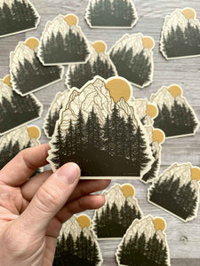 mountains and evergreens with sun sticker